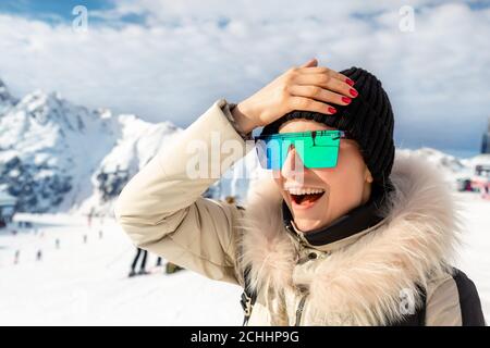 Portrait von schönen jungen Erwachsenen kaukasischen Frau in Sportanzug, Hut, Sonnenbrille lächelnd Blick zur Seite und macht Facepalm erstaunt Gesichtsausdruck auf Stockfoto