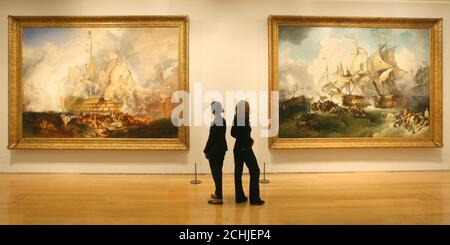 Die Besucher sehen 'The Battle of Trafalgar' von JMW Turner (links) und 'The Glorious First of June' von Philip James de Loutherbourg' (rechts) in der Ausstellung 'Turner and Masters' in der Tate Britain, London. Stockfoto