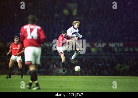 TOTTENHAM HOTSPUR STÜRMER, JURGEN KLINSMANN (R), OUTJUMPS MANCHESTER UNITED DEFENDER, DENIS IRWIN, WÄHREND DES PREMIERSHIP-SPIELS IM ALTEN TRAFFORD. Stockfoto