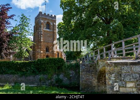 Eine mittelalterliche Papppferdbrücke mit fünf Bögen und der Kirche St. Giles aus dem späten 13. Jahrhundert in Medbourne, Leicestershire, England, Großbritannien Stockfoto