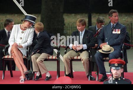 Die Prinzessin von Wales plaudert mit ihrem jüngeren Sohn Prinz Harry, während Prinz Charles und Prinz William während des VJ-Dienstes das Verfahren beobachten. Stockfoto