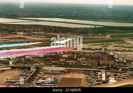 Einen British Airways Concorde führt die Royal Air Force Red Arrows Anzeige Squadron, wie Sie über London Heathrow Flughafen, der feiert sein 50 annniversary war Fliegen. Stockfoto