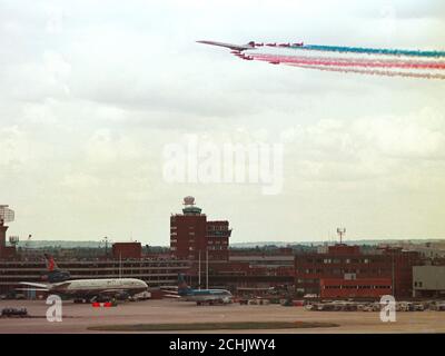 Einen British Airways Concorde führt die Royal Air Force Red Arrows Anzeige Squadron, wie Sie über London Heathrow Flughafen, der feiert sein 50 annniversary war Fliegen. Stockfoto