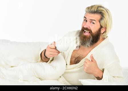 Genießen Sie den morgendlichen Kaffee. Start Tag mit gutem Kaffee. Gourmet-Espresso. Der Körper wurde von wesentlichen Komponenten für eine gute Gesundheit und Energie beraubt. Schöner Mann trinkt Kaffee. Reifer bärtiger Mann im Bett. Stockfoto