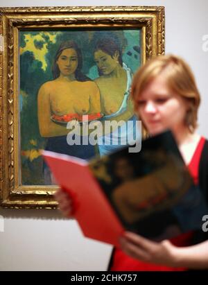 Eine Frau schaut sich einen Katalog vor 'Two Tahitian Women' 1899 an, in der Ausstellung Gauguin: Maker of Myth in der Tate Modern, London. Stockfoto