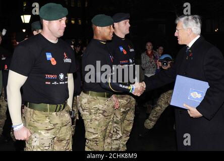 Royal Marine, RAM Pattern, schüttelt die Hand von LT General Sir John Kisley, dem nationalen Präsidenten der Royal British Legion, nachdem er ihm das Buch der Erinnerung als Teams von der Royal Navy, Royal Marines, Armee und RAF beenden den Ehrenmarsch der Royal British Legion auf den Stufen der Royal Albert Hall, London, nach einem 1,000-Meilen-geschwindigkeitsmarsch, der 1 Million für die Wohltätigkeitsorganisation sammeln will. Stockfoto