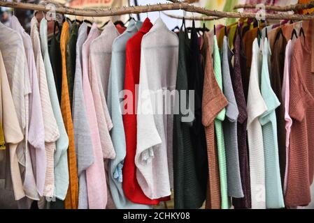 Hängen bunte gestrickte bunte Kleidung - Pullover, Kleider, Strickjacken etc. Stockfoto