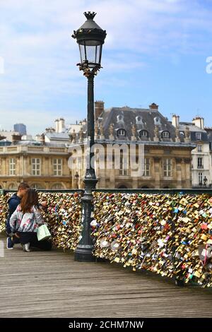 Liebhaber und Vorhängeschlösser in Paris. Zwei Liebhaber verschließen ihr Vorhängeschloss auf Pont des Arts Stockfoto