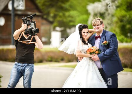 Hochzeitsfotositzung. Der professionelle Videofilmer dreht Jungvermählte: Rezekne, Lettland, 27. Mai 2017 Stockfoto