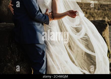 Nahaufnahme der Braut und des Bräutigams umarmen einander Unter dem Sonnenlicht Stockfoto