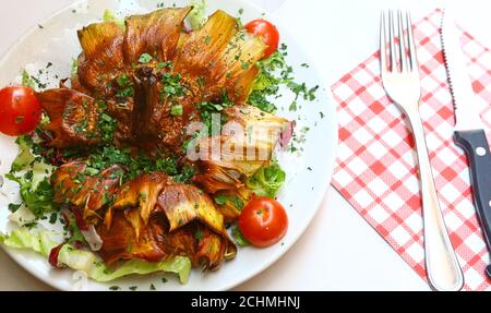 Carciofi alla giuda, wörtlich jüdische Artischocken, gehört zu den bekanntesten Gerichten der römischen Küche. Stockfoto