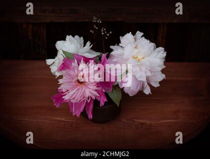 Bouquet von weißen und rosa Pfingstrosen auf dem Holzhintergrund. Drei Pfingstrosen Stockfoto