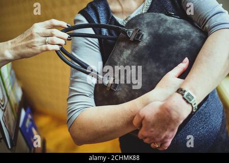 Die Hand des Räubers reißt den Beutel aus den Händen Einer Frau Stockfoto