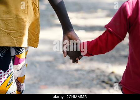 Zwei afrikanische schwarze Brüder halten Hände im Freien im Dorf in der Nähe von Bamako, Mali Stockfoto