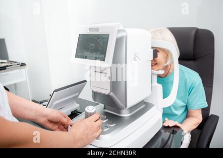Der Arzt kontrolliert die Sehkraft einer älteren Frau. Moderne Klinik zur Kontrolle und Behandlung des Sehvermögens Stockfoto