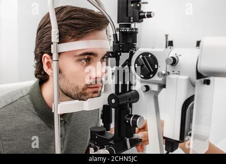 Erwachsener Mann, der eine Augenuntersuchung in der Augenklinik erhält. Überprüfung der Netzhaut eines männlichen Auges aus der Nähe Stockfoto