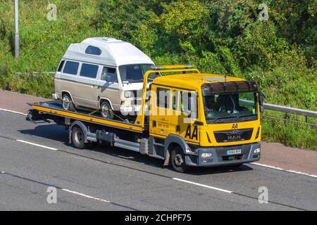 AA 24-Stunden-Pannenrückgewinnung am Straßenrand; weißer T25 VW Volkswagen auf MAN-LKW, Wohnmobile, Wohnmobil auf britischen Straßen, Wohnmobil-Freizeitfahrzeug, Familienurlaub, Karawanenurlaub, Touring-Caravan-Urlaub, Van-Umbauten, Vanagon autohome, Straßenrettung auf der Autobahn M61, Großbritannien Stockfoto