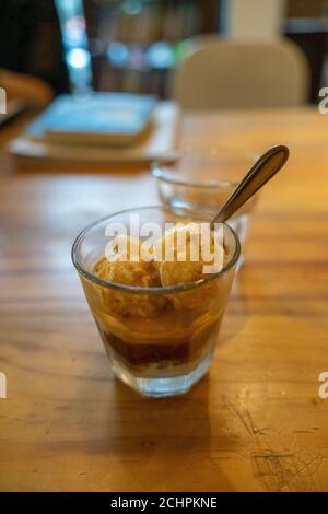 Kalte Brew Eiskaffee Affogato, Vanilla Ice-Cream in einem Glas auf Holztisch Hintergrund in vietnamesischen Café. Essen und Trinken Konzept. Stockfoto