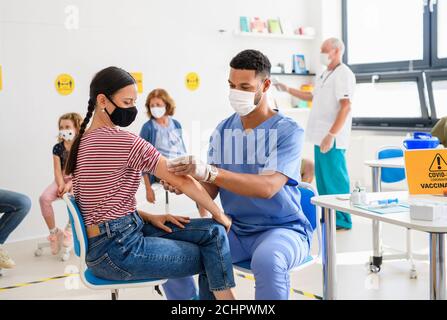 Frau mit Gesichtsmaske geimpft, Coronavirus, covid-19 und Impfkonzept. Stockfoto