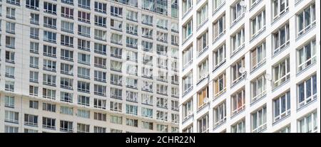 Blick auf ein hohes Wohn-Apartmenthaus mit vielen Fenstern und Balkons. Stockfoto