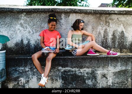 Junge Teenager Mädchen Freunde mit Skateboards im Freien in der Stadt, sitzen. Stockfoto