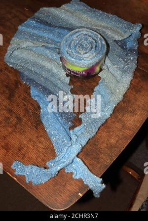 Ein Drachenzahn Schal in Blautönen von Hand gestrickt und der Ball oder Kuchen aus "Northern Lights" Garn, aus dem es gestrickt wurde. Stockfoto