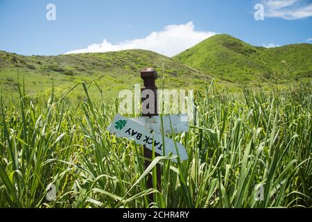 Christiansted, St. Croix, US Jungferninseln-Juli 3,2014: Upside down Jack Bay Trail sign on with rolling Hill Landscape in Remote St. Croix Stockfoto