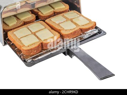 Horizontaler Schuss von vier Stück gebuttertes Weizenbrot, das in den Toaster geschoben und geröstet werden soll. Stockfoto