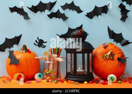 Blauer Hintergrund mit Kürbissen und Halloween-Accessoires, ein fröhliches festliches Partykonzept für Oktoberdekorationen Stockfoto