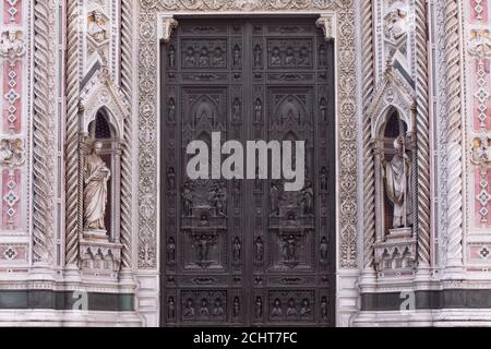 Nahaufnahme der kunstvoll geschnitzten Tür, Eingang zum Duomo Santa Maria del Fiore, (Kathedrale Santa Maria del Fiore). Detail, Fassade der Kathedrale Florenz Stockfoto