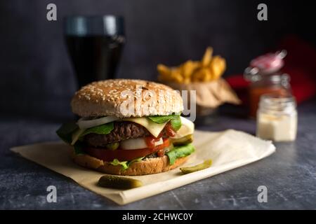 Handgemachter Burger mit Pommes Frites mit Ketchup und Cola auf dunkel Hintergrund Stockfoto