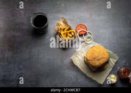 Handgemachter Burger mit Pommes Frites und Zwiebelringen und Cola Stockfoto