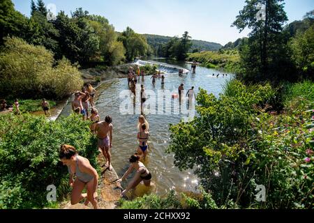 Die Menschen genießen das Wasser in Warleigh Weir am Fluss Avon in Somerset an dem Tag, an dem die "Herrschaft der sechs" Coronavirus-Beschränkungen in Kraft treten. Stockfoto