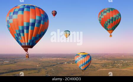 Fünf bunte Luftballons in der Luft über den Ebenen. Stockfoto