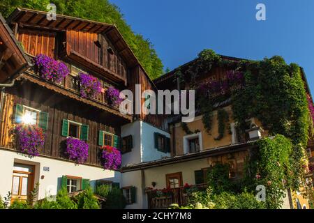 Hallstatt, Österreich-August 10,2020.typisch österreichische Architektur. Holzhäuser mit Balkon und bunten Blumen in Töpfen. Städtische Stadtszene. Rustikale Alpi Stockfoto