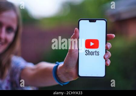 : Youtube Shorts App-Logo auf dem Smartphone, die von jungen Mädchen halten gesehen. Es ist eine neue kurze Looping Video-App, Konkurrent zu TikTok, Bytes und Rollen Stockfoto