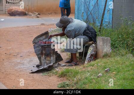 Afrikanische Frau macht 'Shisenyama' Street Barbecue in Soweto Township, Südafrika Stockfoto