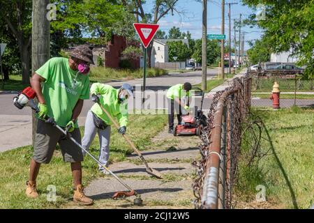 Detroit, Michigan - Arbeiter der Detroit Grounds Crew säubern einen überwucherten Bürgersteig. Stockfoto