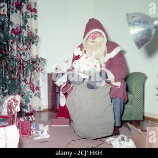 1950 Mann in St. Nikolaus-Outfit in einem Wohnhaus, Deutschland Stockfoto