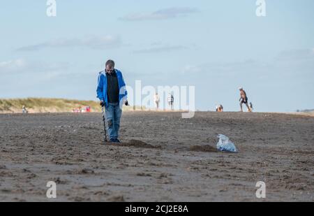 Detektorist mit Metalldetektor am Strand von Anderby Creek, Lincolnshire, England. Stockfoto