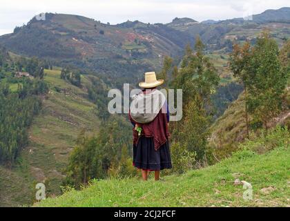 Indigene quechua-Frau, die den Horizont in den Anden, Cajamarca, Peru, betrachtet. Stockfoto