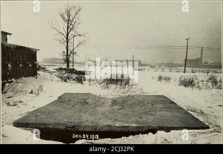 . Die Theorie der Biegung und Festigkeit von rechteckigen flachen Platten auf Stahlbeton Bodenplatten angewendet. Abb. 18. Ausfall der ^Pilzscheibe.. Abb. 19. Ausfall der ISIushroom Slab. Last Entfernt. AUSFALL DER PILZTESTPLATTE 93 8. Die Platte trug ihre Endlast von über 120 Tonnen für vierundzwanzig Stunden ohne zu geben. Sie demonstrierte die Unmögliche ihres plötzlichen Scheiterns, indem sie allmählich nachgab, bis sie eine endgültige Ablenkung von etwa neun Zoll erreichte, wie in den Ansichten vom 17. Dezember und 24. Dezember, Fig. 18 und 19. 9. Während die Stahlplatte in jedem Band war die gleiche wie in der Norcross-Platte, t Stockfoto