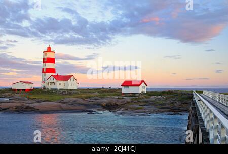 Pointe-des-Monts Leuchtturm bei Sonnenuntergang mit Spiegelungen im Meer, Cote-Nord, Quebec Stockfoto