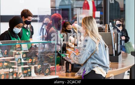 Toronto, Kanada. September 2020. Ein Gast mit Gesichtsmaske kauft am 14. September 2020 in einem Starbucks Café in Toronto, Kanada, Kaffee. Masken oder andere Gesichtsbezüge sind ab Montag bei Starbucks in ganz Kanada Pflicht. Quelle: Zou Zheng/Xinhua/Alamy Live News Stockfoto