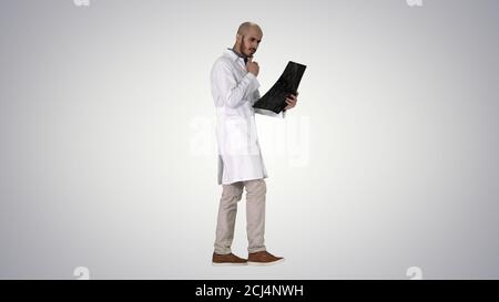 Junger männlicher Arzt, der einen MRT-Hirnscan liest und überprüft Wil Stockfoto