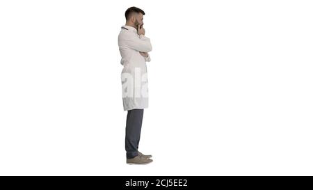 Doktor steht und denkt hart auf weißem Hintergrund. Stockfoto