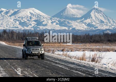 Japanische Sport Utility Vehicle Suzuki Jimny Fahren entlang der Straße auf Hintergrund schöne Winterlandschaft Reiseziele - aktiver Vulkan Stockfoto