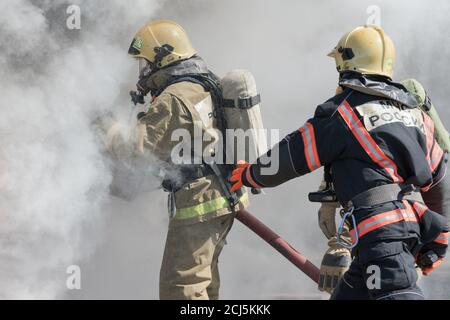 Die Feuerwehr löscht das Feuer aus dem Löschschlauch, indem sie Wasser-Schaumstofffass mit luftmechanischem Schaum verwendet. Professioneller Urlaub Feuerwehrmann Tag Stockfoto