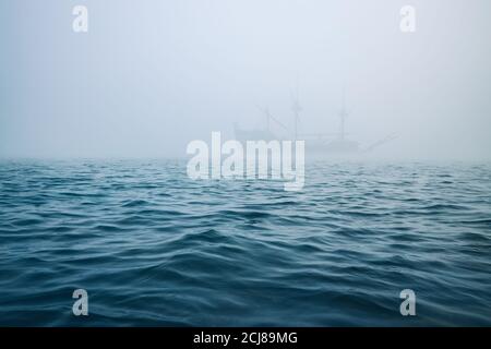 Nebel über den Meereswellen, und neblige Schiff auf einem Hintergrund Stockfoto