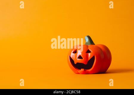 Halloween Kürbis auf orangefarbenem Hintergrund. Halloween Minimal Konzept. Stockfoto